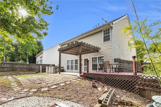 back of house featuring a deck, a pergola, and a fenced backyard