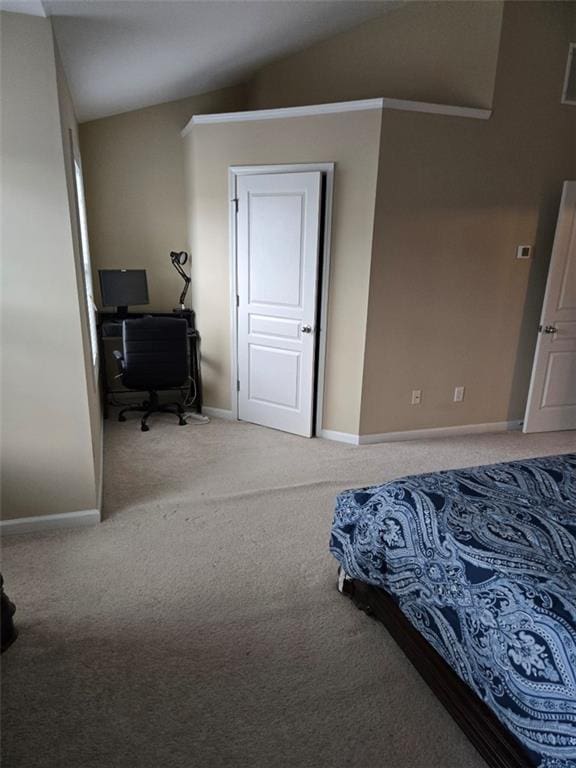 carpeted bedroom with vaulted ceiling and baseboards