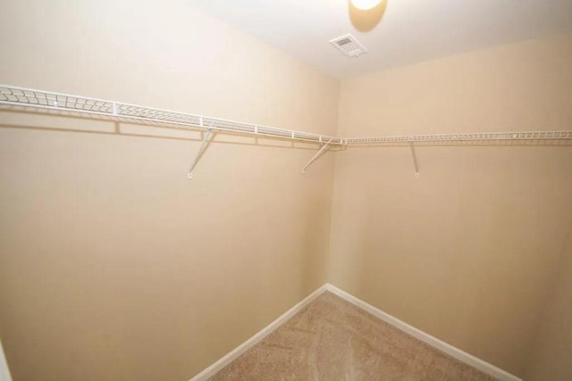 spacious closet with visible vents and light colored carpet