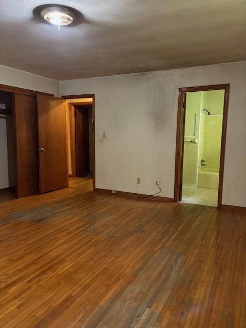 1902 Godby Rd, Atlanta, GA 30349 - unfurnished bedroom with dark hardwood / wood-style flooring, connected bathroom, and a closet