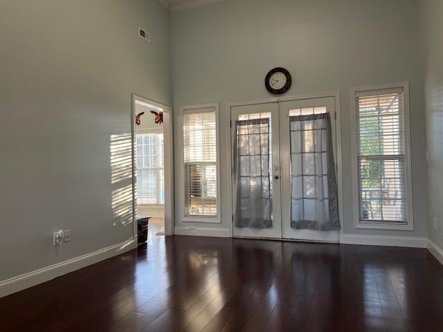 interior space featuring french doors, a towering ceiling, and dark hardwood / wood-style floors