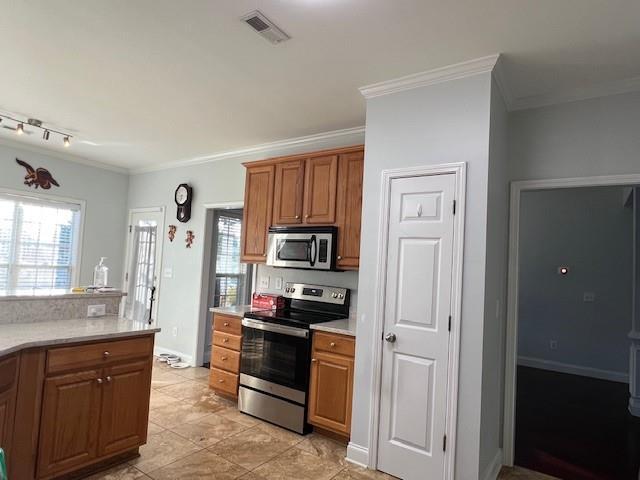 kitchen with ornamental molding and appliances with stainless steel finishes