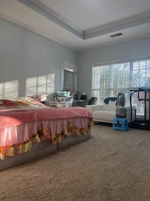 carpeted bedroom with ornamental molding and a tray ceiling