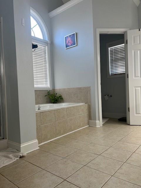 bathroom with tile patterned flooring, shower with separate bathtub, and crown molding