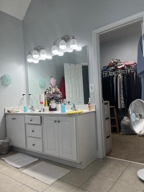 bathroom with vanity, vaulted ceiling, and tile patterned floors