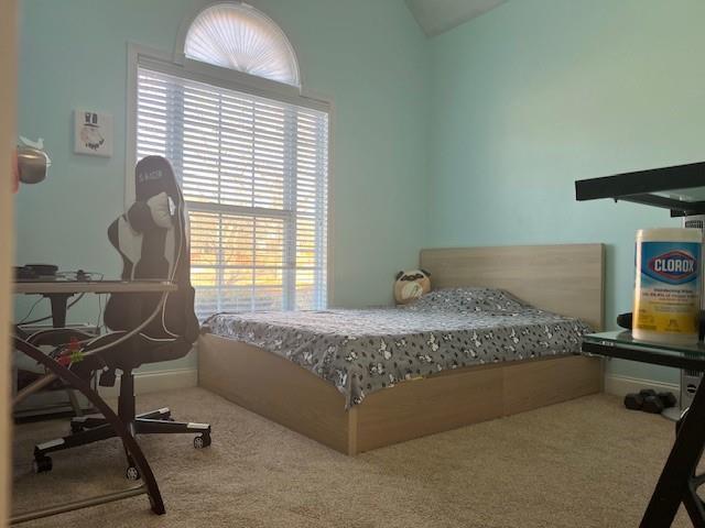 bedroom featuring vaulted ceiling and carpet flooring