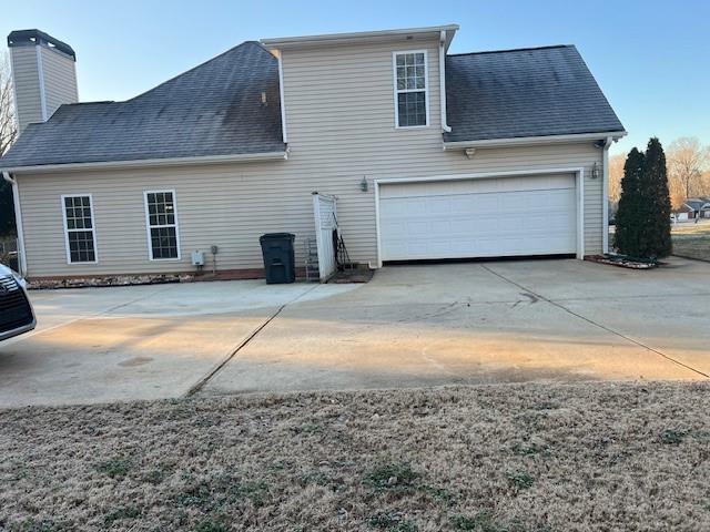 back of house featuring a garage