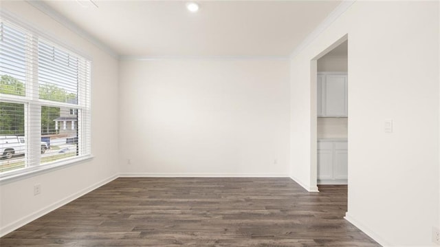 spare room with ornamental molding and dark hardwood / wood-style flooring