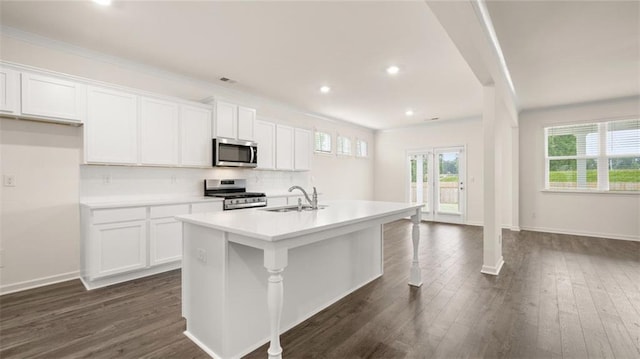 kitchen featuring sink, stainless steel appliances, white cabinets, and a kitchen island with sink