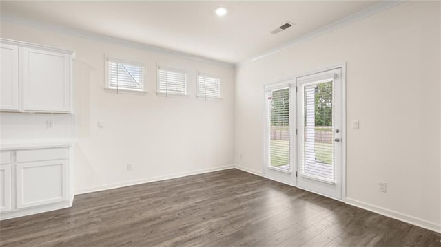 unfurnished dining area featuring crown molding and dark hardwood / wood-style floors