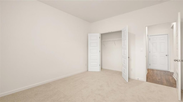 unfurnished bedroom with a closet and light carpet