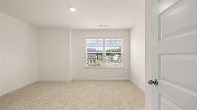 spare room featuring light colored carpet