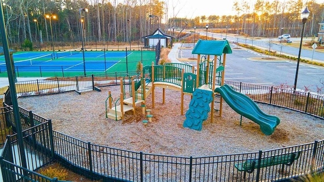 playground at dusk featuring tennis court