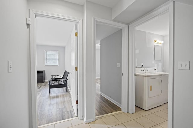 clothes washing area featuring light wood-type flooring and washing machine and dryer