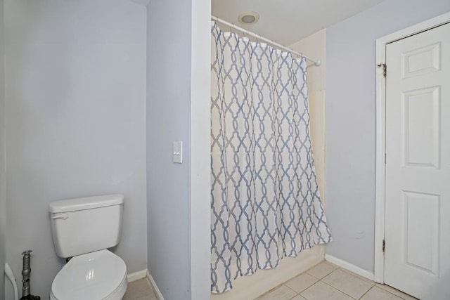 bathroom with shower / tub combo with curtain, toilet, and tile patterned flooring