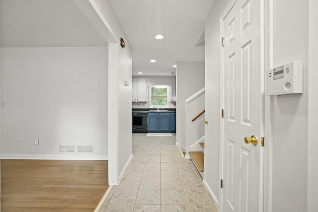 corridor with sink and light hardwood / wood-style flooring