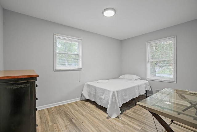 bedroom featuring multiple windows and hardwood / wood-style flooring