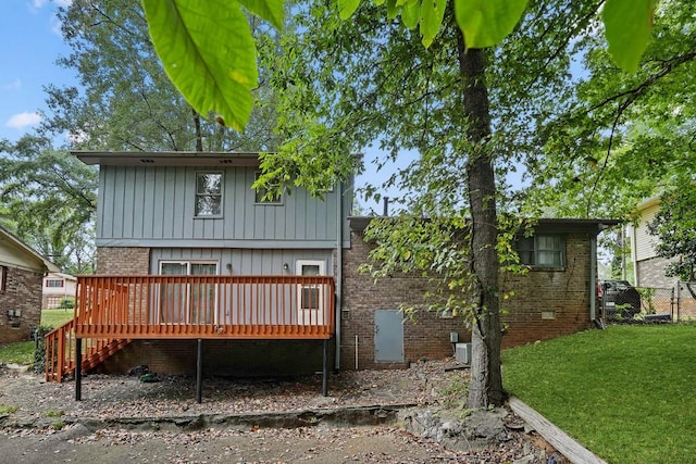 rear view of property with a lawn and a deck