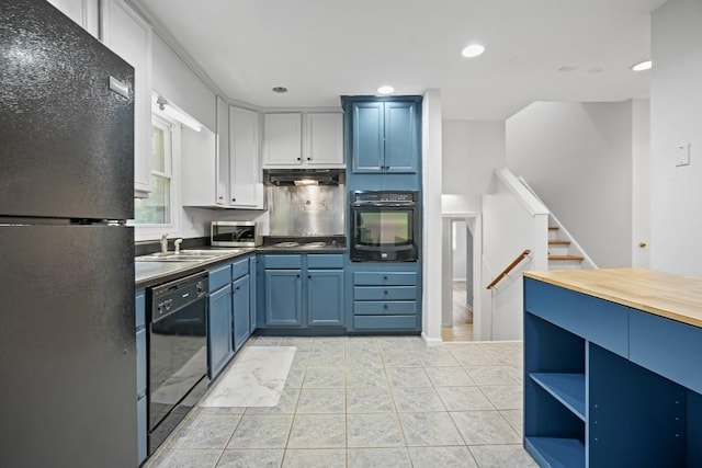 kitchen with blue cabinets, sink, light tile patterned floors, and black appliances