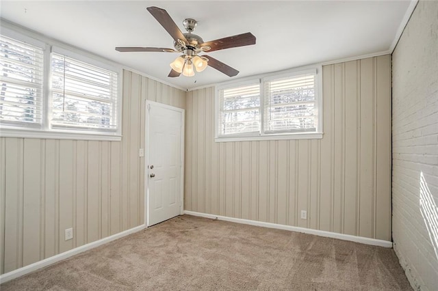 unfurnished room featuring carpet flooring, baseboards, and ceiling fan