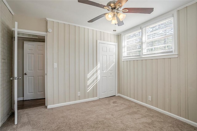 unfurnished bedroom with a ceiling fan, baseboards, and light carpet