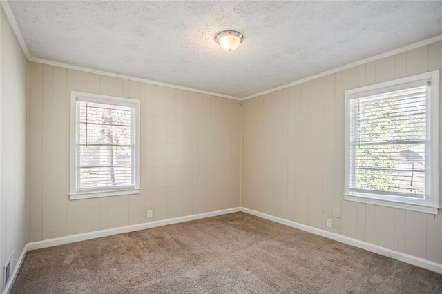 carpeted empty room with visible vents, baseboards, and a textured ceiling