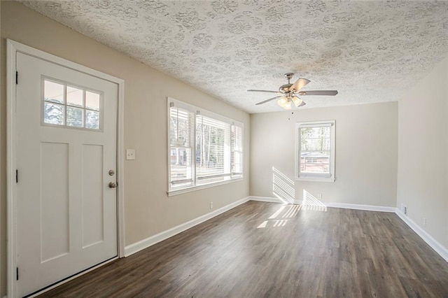 entrance foyer with a textured ceiling, a ceiling fan, baseboards, and dark wood-style flooring