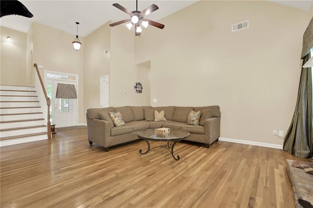 34 Laurel Way NE, White, GA 30184 - living room featuring ceiling fan, high vaulted ceiling, light wood-type flooring, baseboards, and stairway