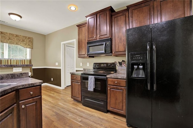 34 Laurel Way NE, White, GA 30184 - kitchen featuring black appliances, light wood-style floors, dark countertops, baseboards, and a sink
