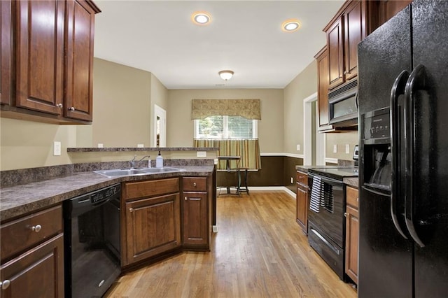 34 Laurel Way NE, White, GA 30184 - kitchen featuring black appliances, a sink, light wood-style flooring, dark countertops, and a peninsula