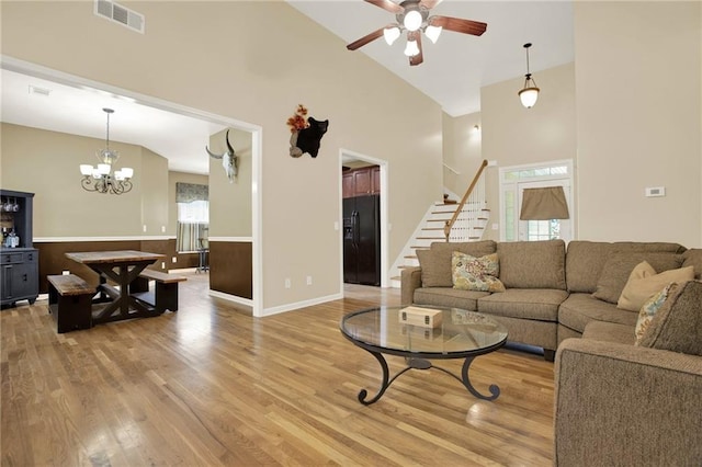 34 Laurel Way NE, White, GA 30184 - living room with high vaulted ceiling, ceiling fan, light wood-style flooring, stairway, and a chandelier