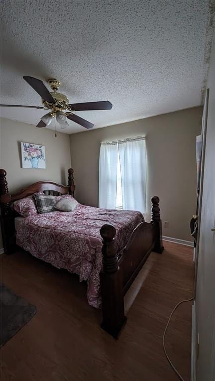 bedroom featuring a textured ceiling, ceiling fan, and dark hardwood / wood-style flooring