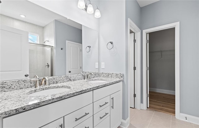 402 Beacon Way, Villa Rica, GA 30180 - full bath with a stall shower, baseboards, double vanity, a walk in closet, and tile patterned floors