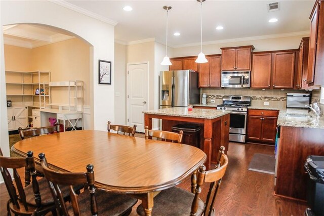 6892 Big Sky Dr, Flowery Branch, GA 30542 - dining area featuring arched walkways, dark wood-style floors, ornamental molding, and recessed lighting