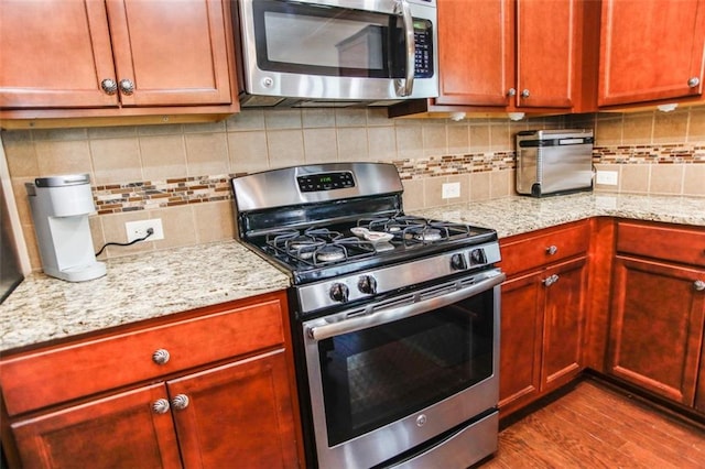 6892 Big Sky Dr, Flowery Branch, GA 30542 - kitchen with appliances with stainless steel finishes, dark wood-style floors, backsplash, and light stone countertops