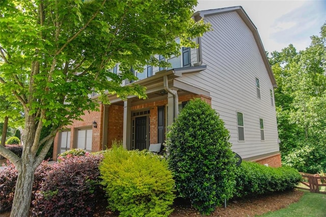 6892 Big Sky Dr, Flowery Branch, GA 30542 - view of side of property featuring brick siding and a porch