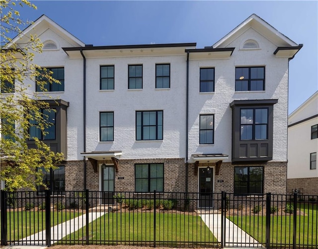 townhome / multi-family property featuring a front lawn