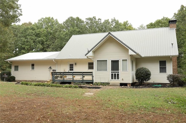 back of property featuring a deck and a yard