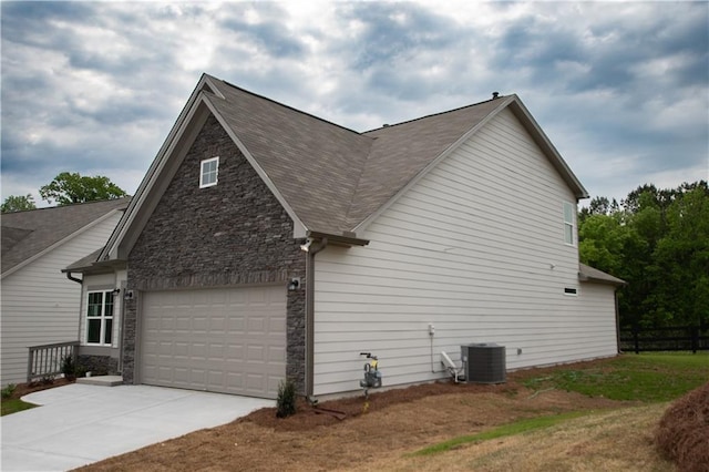 view of side of property featuring a garage and central air condition unit