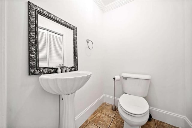 bathroom featuring crown molding, tile patterned floors, and toilet