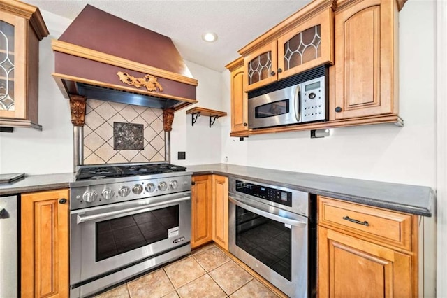 kitchen featuring backsplash, light tile patterned floors, custom exhaust hood, and appliances with stainless steel finishes