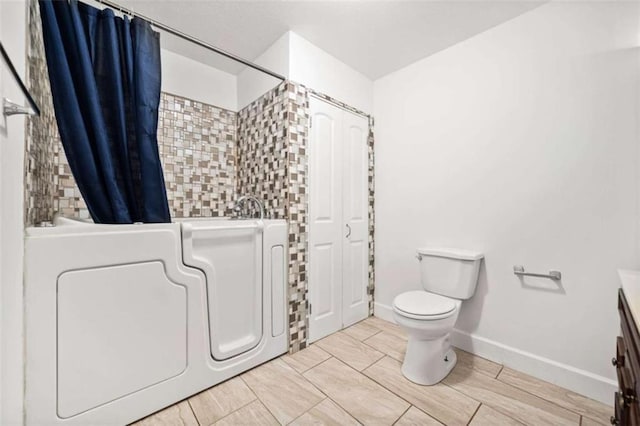 full bathroom featuring shower / bathtub combination with curtain, vanity, and toilet