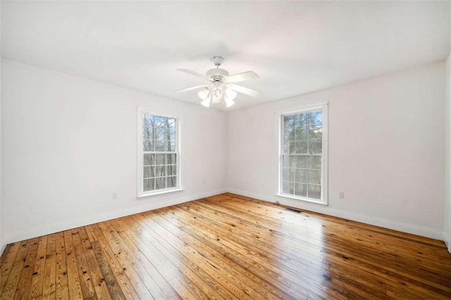 empty room with hardwood / wood-style flooring and ceiling fan