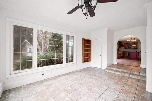 tiled spare room with ceiling fan with notable chandelier, a wealth of natural light, and ornamental molding