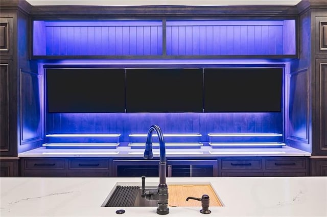 kitchen featuring light stone counters and sink