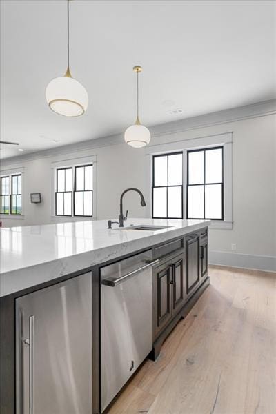 kitchen featuring dishwasher, refrigerator, sink, hanging light fixtures, and light stone countertops