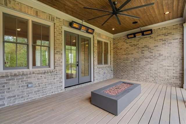 wooden deck with ceiling fan, an outdoor fire pit, and french doors