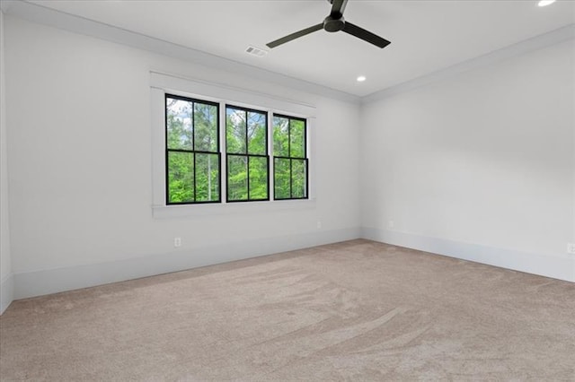 carpeted spare room featuring ceiling fan and crown molding