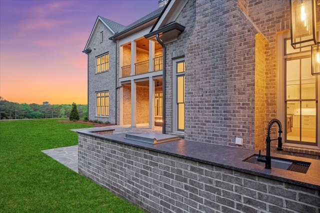 exterior space featuring a yard and sink