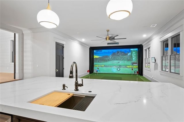 kitchen featuring decorative light fixtures, ceiling fan, crown molding, and sink